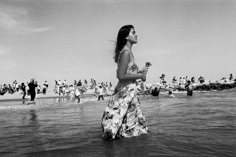 gitane représentée en robe les pieds dans la mer, lors du pélerinnage